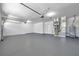 Spacious three car garage featuring epoxy floors and neutral paint with plenty of room at 15714 Ibisridge Dr, Lithia, FL 33547