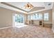Living room with tile floors, tray ceiling with fan, built-in shelves, sliding doors to the patio, and lots of natural light at 15714 Ibisridge Dr, Lithia, FL 33547