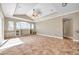 Cozy living area featuring tile floors, tray ceiling with fan, built-in shelving, and large windows for natural light at 15714 Ibisridge Dr, Lithia, FL 33547