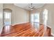 Bright living room features hardwood floors, neutral paint, ceiling fan, and a glass sliding door to the patio at 15714 Ibisridge Dr, Lithia, FL 33547
