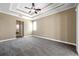 Large carpeted main bedroom with trey ceiling, fan, neutral paint, and bathroom doorway at 15714 Ibisridge Dr, Lithia, FL 33547