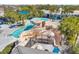 Aerial view of community pool with waterfall, slide, and sunbathing area surrounded by palm trees at 15714 Ibisridge Dr, Lithia, FL 33547