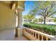Covered porch view with decorative railing and view of the lush landscaping and street at 15714 Ibisridge Dr, Lithia, FL 33547