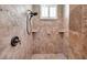 Close-up of tiled walk-in shower with shower head and corner shelves, illuminated by a window at 15714 Ibisridge Dr, Lithia, FL 33547