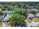 An aerial view of a neighborhood showcasing mature trees and the home with an extended driveway at 16039 Frost Dr, Hudson, FL 34667