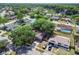 An aerial view showcases a residential neighborhood, mature trees, and blue water in the distance at 16039 Frost Dr, Hudson, FL 34667