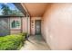Inviting front entrance with a decorative door, modern light fixture, and manicured shrubbery at 16039 Frost Dr, Hudson, FL 34667