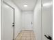 Neutral hallway with tile flooring, white walls, and minimalist lighting at 16039 Frost Dr, Hudson, FL 34667