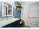 Stylist bathroom with a vanity featuring lots of storage space and a blue accent wall at 1800 Salem Ct, Dunedin, FL 34698