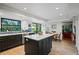 Modern kitchen features a center island, stainless steel appliances, and a view of the outdoor pool at 1800 Salem Ct, Dunedin, FL 34698