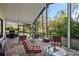 Relaxing screened-in patio with brick pavers, outdoor seating, and views of the lush backyard at 1800 Salem Ct, Dunedin, FL 34698