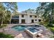 Backyard oasis featuring a pool, hot tub, brick patio, and manicured landscaping at 1800 Salem Ct, Dunedin, FL 34698