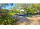 Sparkling pool with brick pavers, flowers, a gazebo, and mature trees in backyard at 1800 Salem Ct, Dunedin, FL 34698