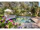 Beautiful pool area with a spa, gazebo, lovely landscaping, and a brick paver patio at 1800 Salem Ct, Dunedin, FL 34698