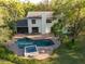 Aerial view of backyard oasis with a sparkling pool, hot tub, and lush greenery at 1800 Salem Ct, Dunedin, FL 34698