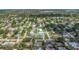 An aerial view of the property situated in a verdant neighborhood with beautiful landscaping and many nearby homes at 1881 Stancel Dr, Clearwater, FL 33764