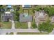 Aerial view of home with a backyard pool, driveway parking, and mature landscaping in a residential neighborhood at 1881 Stancel Dr, Clearwater, FL 33764