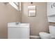 Bathroom showcasing a white vanity with sink, toilet and storage cabinet on the wall at 1881 Stancel Dr, Clearwater, FL 33764