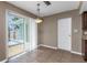 Bright dining area featuring tile floors, a modern light fixture, and sliding glass doors to the pool area at 1881 Stancel Dr, Clearwater, FL 33764