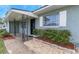 Inviting home entrance with a covered porch, rock landscaping, and a dark front door at 1881 Stancel Dr, Clearwater, FL 33764