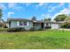 Charming single story home with a well-maintained lawn and attached garage under a cloudy blue sky at 1881 Stancel Dr, Clearwater, FL 33764
