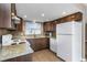 Clean kitchen featuring a white refrigerator and matching appliances with granite countertops at 1881 Stancel Dr, Clearwater, FL 33764