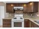 Traditional kitchen showcasing an electric stove, attractive backsplash, and wooden cabinets at 1881 Stancel Dr, Clearwater, FL 33764