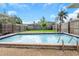 A lovely backyard featuring a refreshing swimming pool surrounded by a well-maintained lawn and a privacy fence at 1881 Stancel Dr, Clearwater, FL 33764