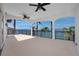 A covered balcony has stately columns and ceiling fans with serene water views at 1901 Carolina Ne Ave, St Petersburg, FL 33703