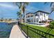 Exterior view of a two-story home with a fenced in pool area, a concrete patio, and manicured grass near the water at 1901 Carolina Ne Ave, St Petersburg, FL 33703