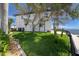Exterior image of a luxury home's yard with manicured lawn, palm trees, and a glimpse of the water at 1901 Carolina Ne Ave, St Petersburg, FL 33703