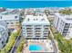 Aerial view of condo with a luxurious pool and lounging area in desirable beach community at 19925 Gulf Blvd # 402, Indian Shores, FL 33785