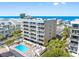 Scenic aerial view showcasing a condo complex, pool, and stunning ocean views at 19925 Gulf Blvd # 402, Indian Shores, FL 33785
