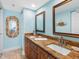 Double sink bathroom vanity with granite countertop, wood cabinets, and decorative mirrors at 19925 Gulf Blvd # 402, Indian Shores, FL 33785