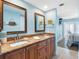 Double sink bathroom vanity with granite countertop, wood cabinets, and decorative mirrors at 19925 Gulf Blvd # 402, Indian Shores, FL 33785