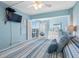 Charming bedroom with a queen bed, blue accents, and balcony access with water views at 19925 Gulf Blvd # 402, Indian Shores, FL 33785