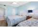 Comfortable bedroom featuring two twin beds, light blue walls and a ceiling fan at 19925 Gulf Blvd # 402, Indian Shores, FL 33785