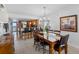 Light and bright dining room with table set for six, chandelier and open to kitchen and living area at 19925 Gulf Blvd # 402, Indian Shores, FL 33785