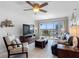 Comfortable living room with tile flooring, ceiling fan, furniture, television, and sliding glass door to balcony at 19925 Gulf Blvd # 402, Indian Shores, FL 33785