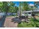 Spacious backyard featuring a brick patio, lounge seating, an outdoor kitchen and mature trees at 202 S Hesperides St, Tampa, FL 33609