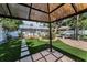 Backyard featuring an outdoor kitchen, lounge seating, brick patio, artificial turf, and mature trees at 202 S Hesperides St, Tampa, FL 33609