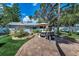 Spacious backyard with a brick patio, lounge seating, mature trees, and a well-manicured lawn at 202 S Hesperides St, Tampa, FL 33609