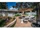 Inviting backyard with brick patio, outdoor seating, mature trees, and well-maintained landscaping for relaxation at 202 S Hesperides St, Tampa, FL 33609