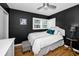 Cozy bedroom with black walls, white bedding, a ceiling fan and hardwood floors at 202 S Hesperides St, Tampa, FL 33609