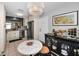 Dining area with marble table, stylish chairs, art, chandelier, and black cabinet with stemware, adjacent to the kitchen at 202 S Hesperides St, Tampa, FL 33609