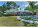 Charming brick home featuring manicured lawn, sidewalk, and meticulous landscaping creates a welcoming curb appeal at 202 S Hesperides St, Tampa, FL 33609
