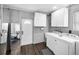 Laundry room with white washer and dryer, storage cabinets, and a mirror on the wall at 202 S Hesperides St, Tampa, FL 33609