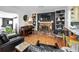 Open living room with wood floors, fireplace, built-in bookshelves, piano, and comfortable leather chairs at 202 S Hesperides St, Tampa, FL 33609