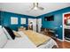 A primary bedroom featuring blue accent walls, mirrored dresser, and king size bed with yellow blanket at 202 S Hesperides St, Tampa, FL 33609