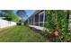 Backyard with lush green grass and a screened in patio running the length of the building at 2213 Fluorshire Dr, Brandon, FL 33511